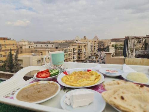 ein Tablett mit Speisen auf einem Tisch auf einem Balkon in der Unterkunft Pyramids Sunrise View Hotel in Giza