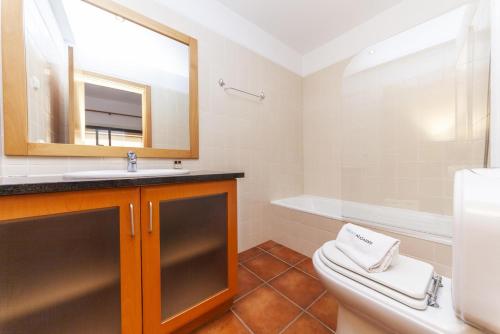 a bathroom with a sink and a toilet and a mirror at C16 - Landeiro MarinaPark Apartment in Lagos
