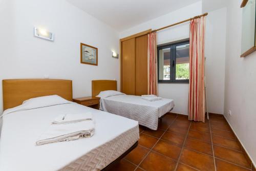 a hotel room with two beds and a window at C16 - Landeiro MarinaPark Apartment in Lagos