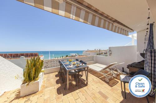 a patio with a table and chairs and the ocean at C22 - Beco do Poço Beach Townhouse in Praia da Luz in Luz