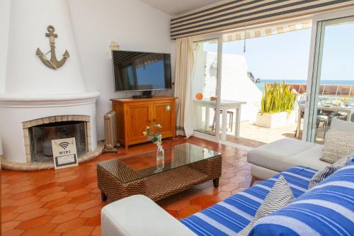 a living room with a fireplace and a tv at C22 - Beco do Poço Beach Townhouse in Praia da Luz in Luz