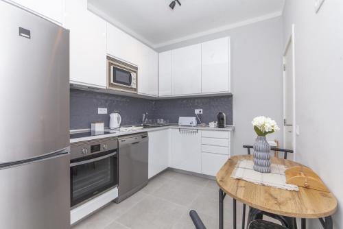 a kitchen with white cabinets and a wooden table at C09 - Portimão 3 Bed Holiday Apartment in Portimão
