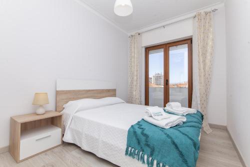 a white bedroom with a bed and a window at C09 - Portimão 3 Bed Holiday Apartment in Portimão