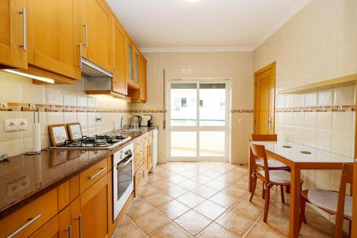a kitchen with wooden cabinets and a table in it at C03 - Galé Holiday Apartment in Lagos in Lagos