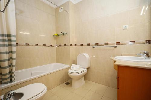 a bathroom with a toilet and a sink and a tub at C03 - Galé Holiday Apartment in Lagos in Lagos