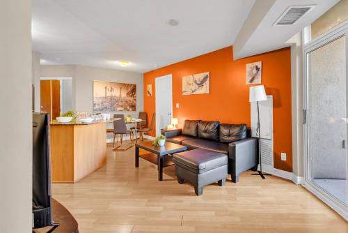 a living room with orange walls and a couch at 2 bedroom spacious apartment in Mississauga in Mississauga