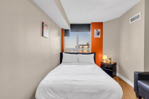a bed in a small room with a window at 2 bedroom spacious apartment in Mississauga in Mississauga