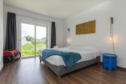 a bedroom with a bed and a large window at D13 - Eiras Velhas Holiday House in Almádena in Almádena