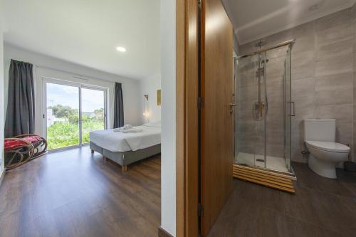 a bathroom with a shower and a toilet and a bed at D13 - Eiras Velhas Holiday House in Almádena in Almádena