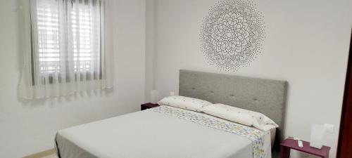 Dormitorio blanco con cama y pared blanca en Estudio - descanso y bienestar en La Punta, en Punta del Hidalgo