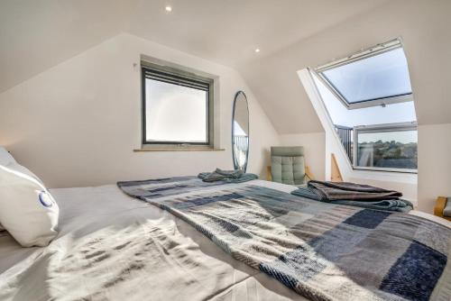 a bedroom with a large bed and two windows at 2 Bed in Crackington Haven oc-h33817 in Crackington Haven