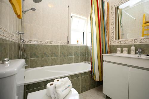 a bathroom with a tub and a toilet and a sink at C13 - Ameijeira Holiday Apartment in Lagos in Lagos