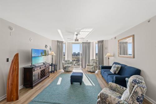 a living room with a blue couch and a tv at Barefoot Resort - North Tower 905 - Windy Hill in Myrtle Beach