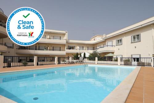 a swimming pool with a sign in front of a building at C19 - Do Mar Apartment in Lagos in Lagos