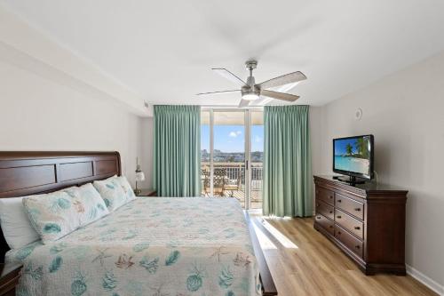 a bedroom with a bed and a flat screen tv at Barefoot Resort - North Tower 905 - Windy Hill in Myrtle Beach