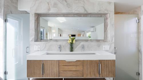 a bathroom with a sink and a mirror at 5 Units in Heart of Hollywood Remodeled Art Deco Pink Revival by AvantStay in Los Angeles