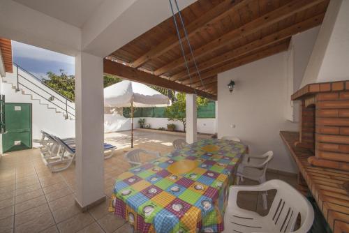 a dining room with a table and chairs and an umbrella at D07 - Torraltinha Villa in Lagos in Lagos