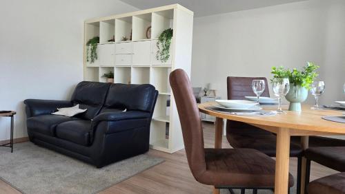 una sala da pranzo con un tavolo e un divano di MaxMir - Tannenweg Iserlohn a Iserlohn