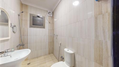 a bathroom with a toilet and a sink at شقق أون يسن للشقق المخدومة in Medina