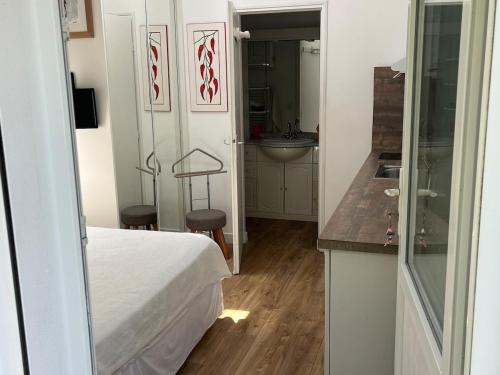 une chambre avec un lit et une salle de bains avec un lavabo dans l'établissement Chambre d'hôtes-studette Biarritz Milady, calme, patio, vue sur jardin et montagne du patio, parkin privé, tout confort, à Biarritz