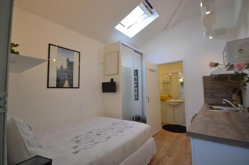 une chambre blanche avec un lit et un lavabo dans l'établissement Chambre d'hôtes-studette Biarritz Milady, calme, patio, vue sur jardin et montagne du patio, parkin privé, tout confort, à Biarritz