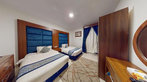 麦地那أونيسن المدينة的一间有两张床和一台电视的酒店房间