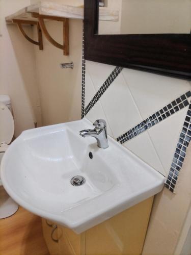 a white sink in a bathroom with a mirror at Brando bnb in King Williamʼs Town