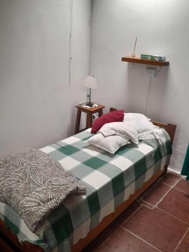 ein Schlafzimmer mit einem Bett mit einer grünen und weißen Decke in der Unterkunft Casa de ensueño a pasos del mar in Camet Norte