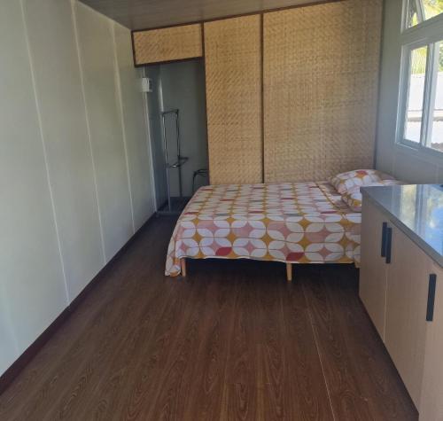 Takava Lodge في فاكارافا: غرفة نوم مع سرير وأرضية خشبية