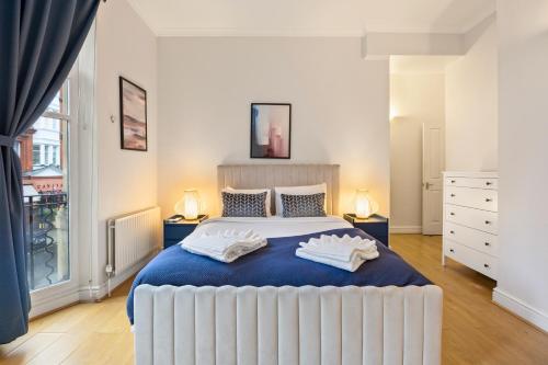a bedroom with a large bed with two towels on it at Private Oxford Street Luxe Apartment in London