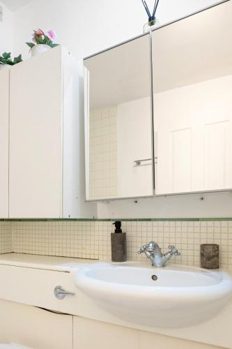 a bathroom sink with a large mirror above it at Private Oxford Street Luxe Apartment in London