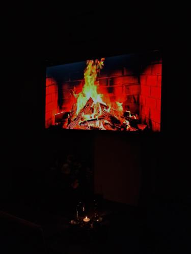 a fire in a fireplace with a tv in it at Cozy and Comfortable Apartment in Kutaisi