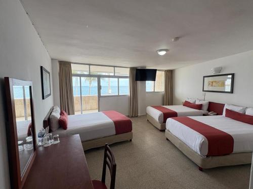 een hotelkamer met twee bedden en een televisie bij Hotel Royalty in Veracruz
