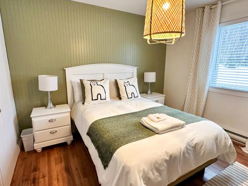 een slaapkamer met een bed met twee nachtkastjes en twee lampen bij Condos Mont-Trinité in Saint-Michel-des-Saints