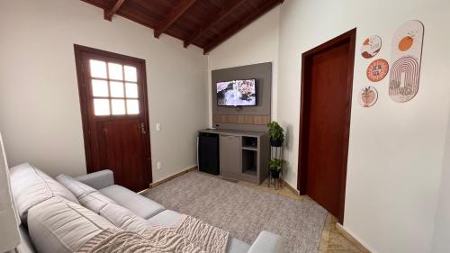 a living room with a white couch and a television at Pousada Vivenza in Laguna