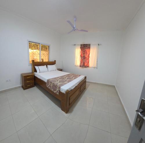 een slaapkamer met een bed en een raam bij JEK Villa in Brufut