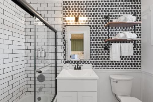 a white bathroom with a sink and a mirror at The Boha Hotel in Lake Placid