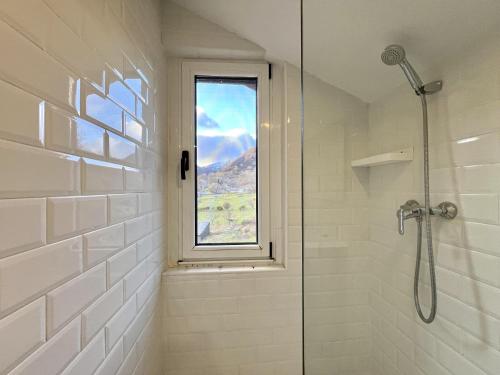 een badkamer met een douche en een raam bij La Casona de Omaña in Fasgar