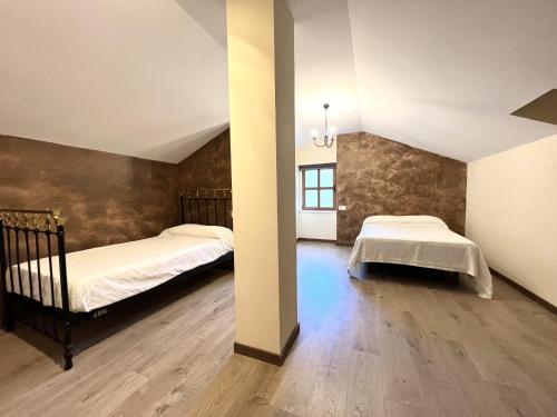 een slaapkamer met 2 bedden en een muur bij La Casona de Omaña in Fasgar