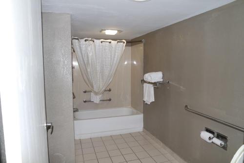a bathroom with a tub and a shower with a curtain at Travelodge by Wyndham North Charleston in Charleston