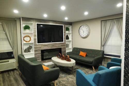 a living room with couches and a tv and a fireplace at Travelodge by Wyndham North Charleston in Charleston