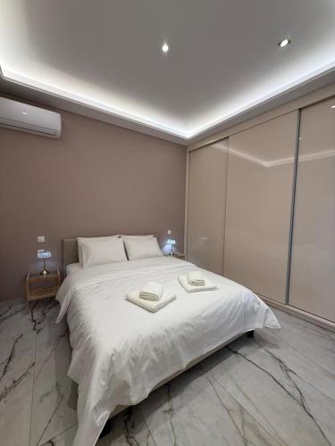 Un dormitorio con una cama grande con sábanas blancas. en Luxy renovated flat with patio, en Atenas