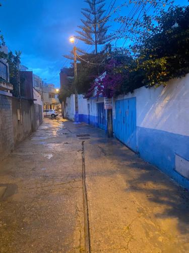 eine leere Straße mit einem blauen und weißen Gebäude in der Unterkunft Petit appartement à martil in Martil