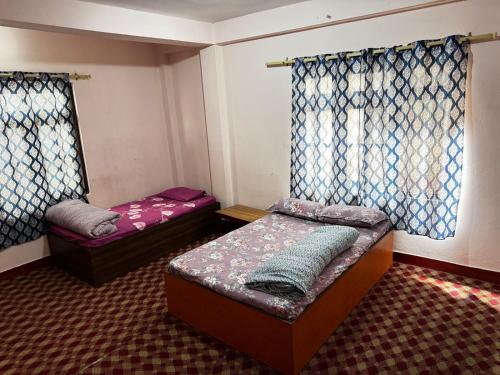 a small room with two beds and a window at new hotel gaule in Bālāju