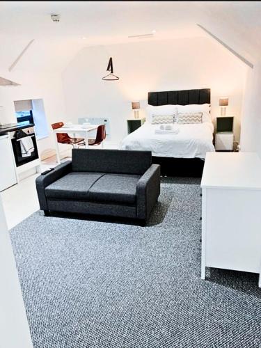 una camera con un letto e un divano nero di Flat 6 - Eign St Hereford a Hereford