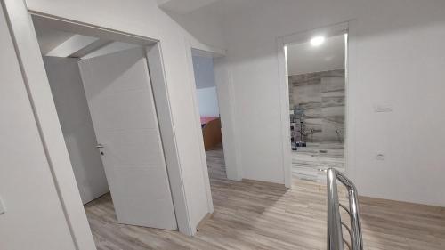 a white room with a hallway with a mirror at Villa Nova Ohrid in Ohrid