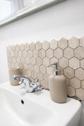 a bathroom sink with a soap dispenser on it at Premium 3BR Penthouse Corporate Stay Parking Sleeps 6 in Lincoln