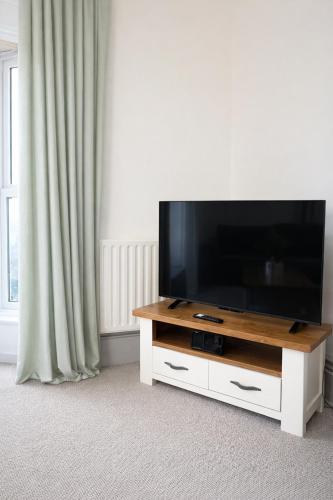 a flat screen tv sitting on top of a white entertainment center at Premium 3BR Penthouse Corporate Stay Parking Sleeps 6 in Lincoln