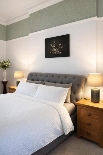 a bedroom with a white bed with a gray headboard at Premium 3BR Penthouse Corporate Stay Parking Sleeps 6 in Lincoln