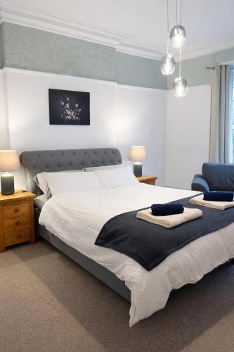 a bedroom with a large bed and a blue chair at Premium 3BR Penthouse Corporate Stay Parking Sleeps 6 in Lincoln